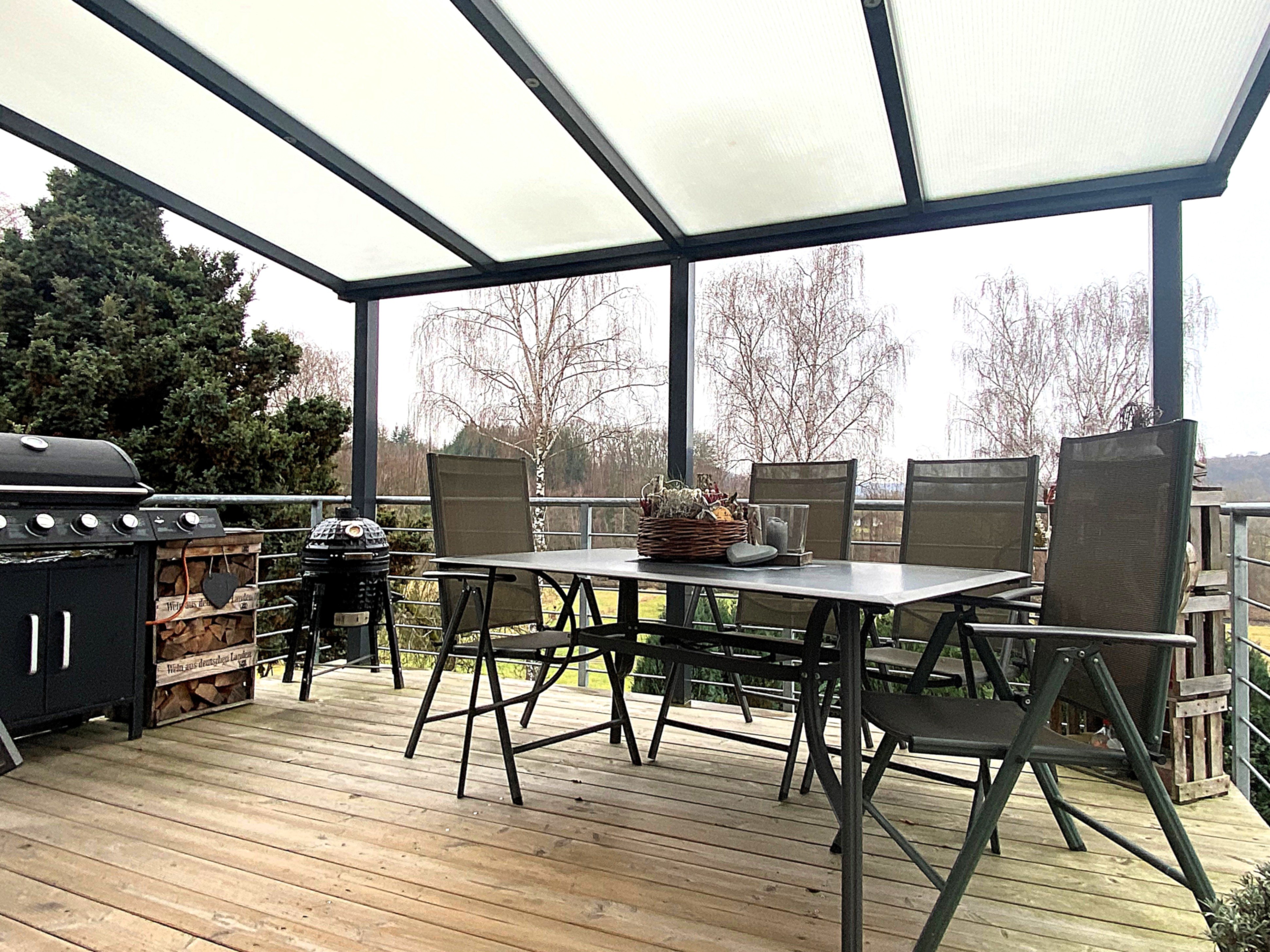 zum überdachten großzügigen Kamin